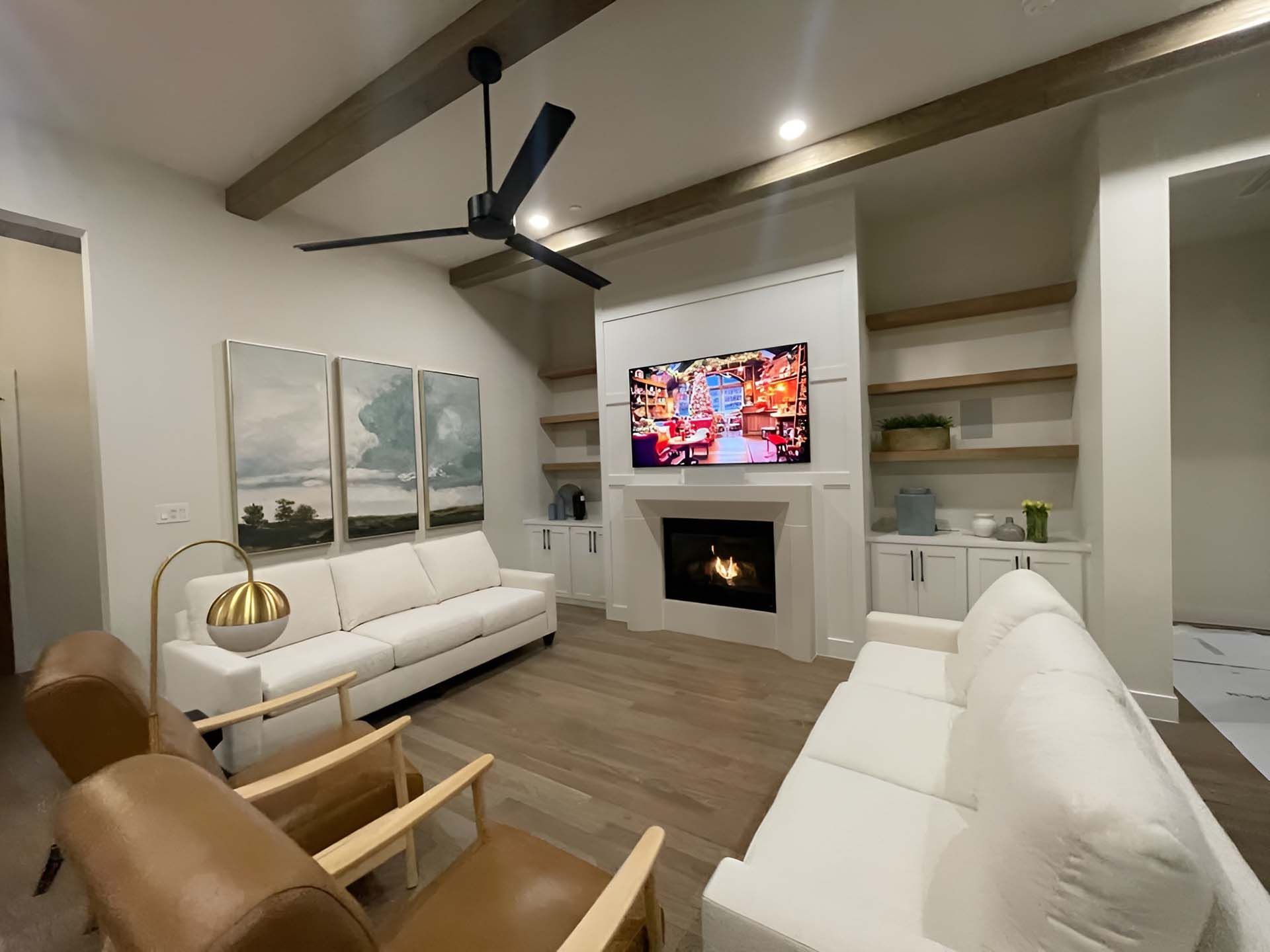 Living room with white couches and a flat screen tv in the middle